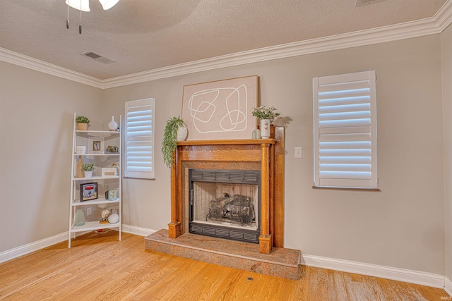 unfurnished living room featuring crown molding, a textured ceiling, and wood-type flooring