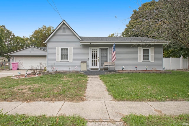 ranch-style house featuring a front yard, a garage, and an outbuilding