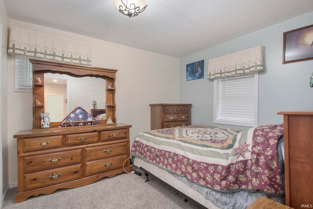 bedroom featuring a textured ceiling and light colored carpet