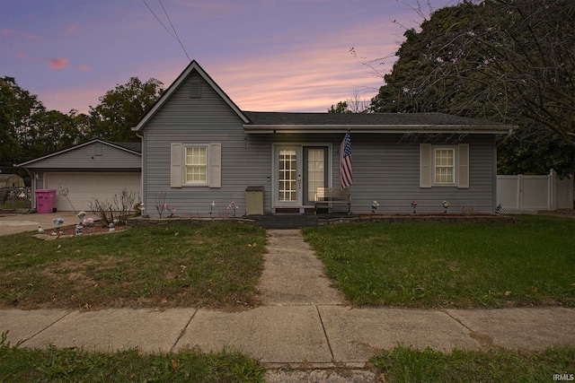 view of front of house with a yard, a garage, and an outdoor structure