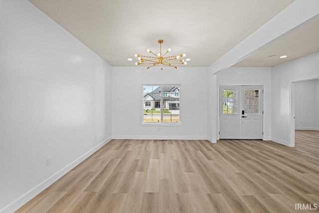 unfurnished dining area with a chandelier, light hardwood / wood-style flooring, and french doors