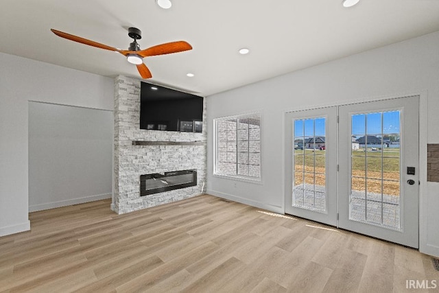 unfurnished living room featuring light hardwood / wood-style flooring, a fireplace, and ceiling fan