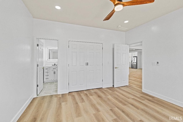 unfurnished bedroom featuring a closet, ceiling fan, light hardwood / wood-style flooring, and ensuite bath