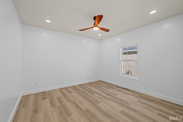 empty room with ceiling fan and light hardwood / wood-style flooring