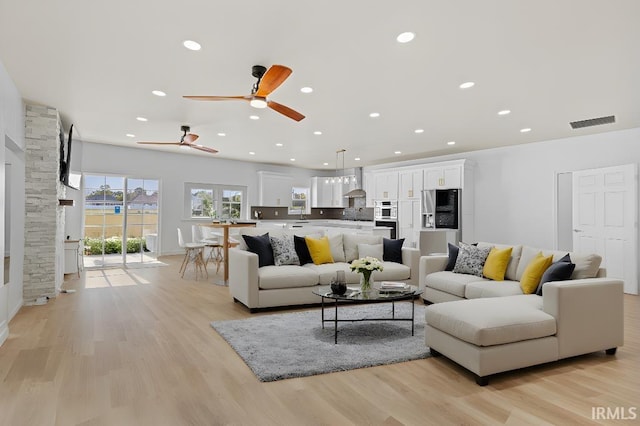 living room with light hardwood / wood-style flooring and ceiling fan