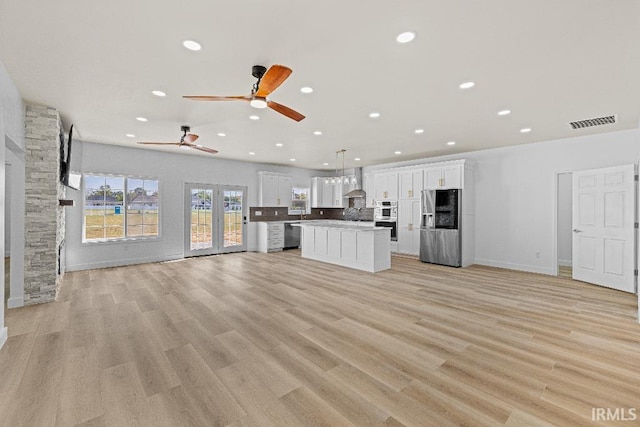 unfurnished living room with light hardwood / wood-style floors and ceiling fan