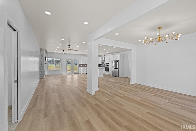 unfurnished living room with french doors, light hardwood / wood-style flooring, and ceiling fan with notable chandelier