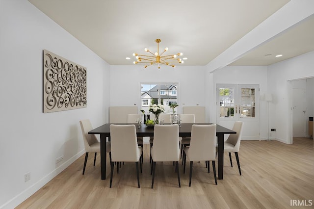 dining space featuring light hardwood / wood-style flooring and a chandelier