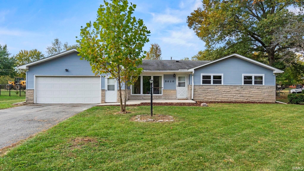 ranch-style home with a garage and a front lawn