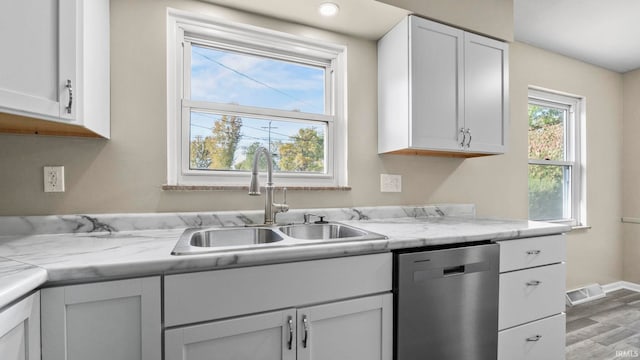 kitchen featuring sink, dishwasher, light wood-type flooring, and white cabinets