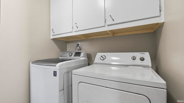 laundry room featuring independent washer and dryer and cabinets