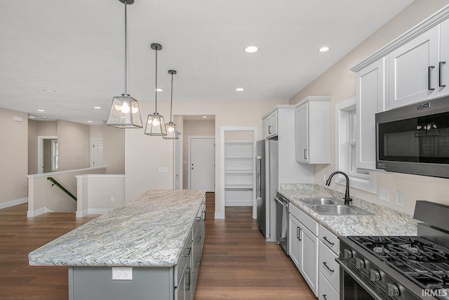 1916 Newbury Cir, Goshen, IN 46526 - kitchen featuring appliances with stainless steel finishes, a kitchen island, dark wood-type flooring, light stone countertops, and pendant lighting