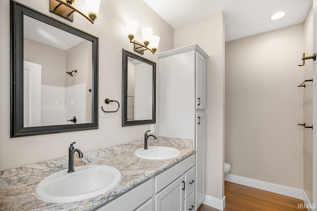 bathroom featuring vanity, toilet, walk in shower, and hardwood / wood-style floors