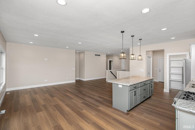 kitchen featuring gray cabinetry, stainless steel appliances, dark hardwood / wood-style flooring, and pendant lighting