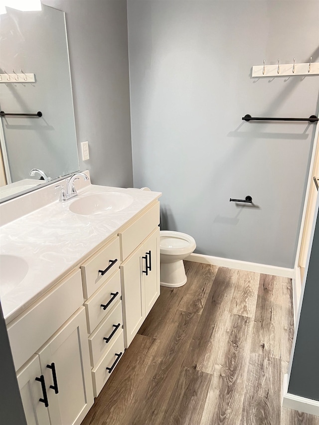 bathroom with vanity, wood-type flooring, and toilet