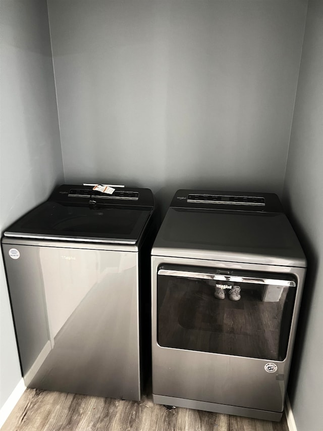 washroom with washing machine and dryer and light wood-type flooring