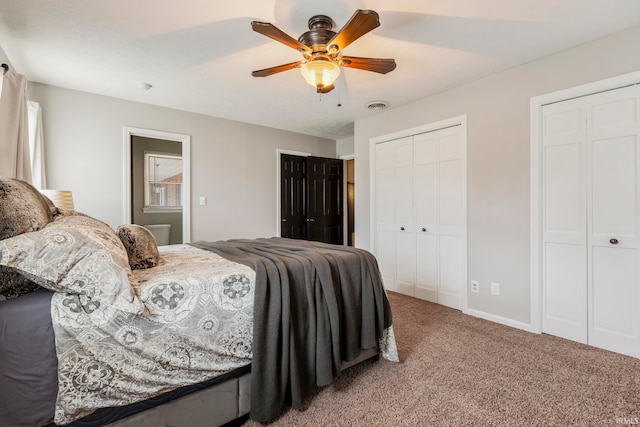 carpeted bedroom featuring two closets and ceiling fan