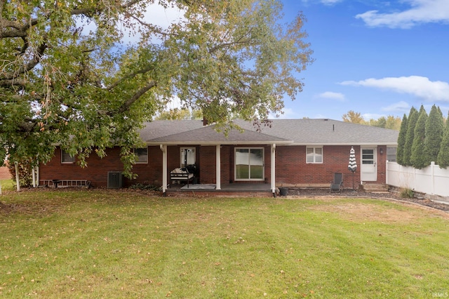 rear view of house featuring a yard, a patio, and central air condition unit