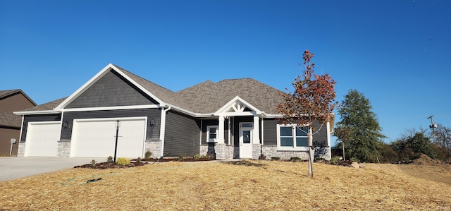 craftsman inspired home featuring a garage and a front lawn