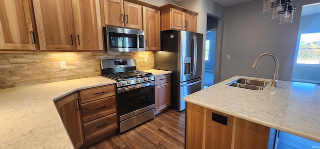 kitchen featuring sink, decorative backsplash, light stone countertops, and appliances with stainless steel finishes