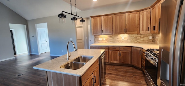 kitchen with vaulted ceiling, appliances with stainless steel finishes, sink, decorative backsplash, and a center island with sink