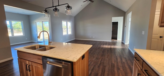 kitchen featuring dishwasher, sink, hanging light fixtures, light stone counters, and a center island with sink