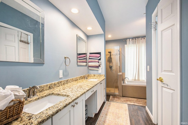 bathroom with vanity, hardwood / wood-style floors, and plus walk in shower