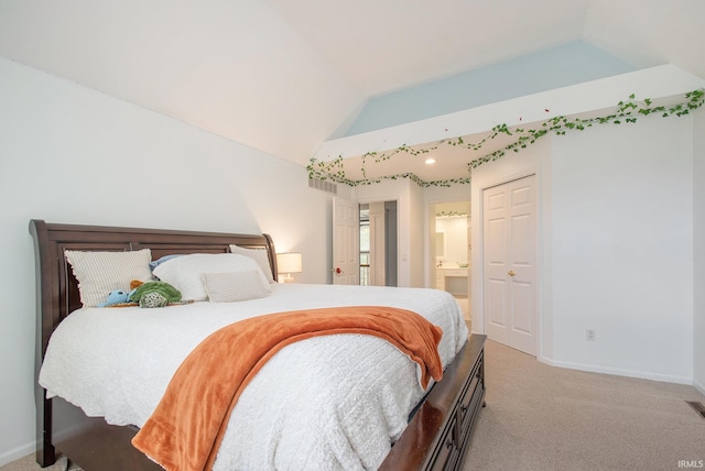 carpeted bedroom with connected bathroom and lofted ceiling