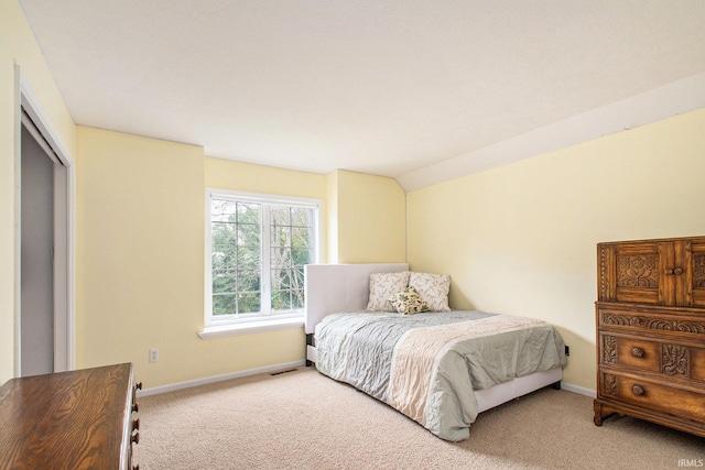 bedroom featuring a closet, lofted ceiling, and carpet floors