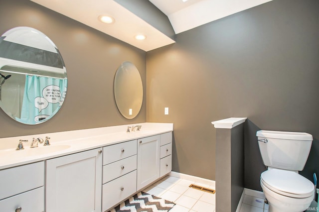 bathroom with toilet, lofted ceiling, vanity, and tile patterned flooring