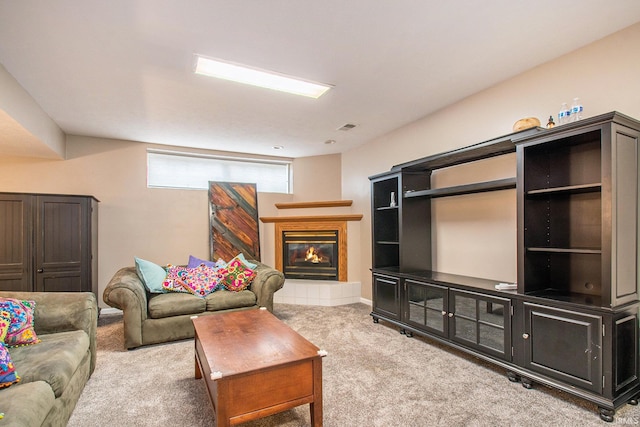 carpeted living room with a tile fireplace