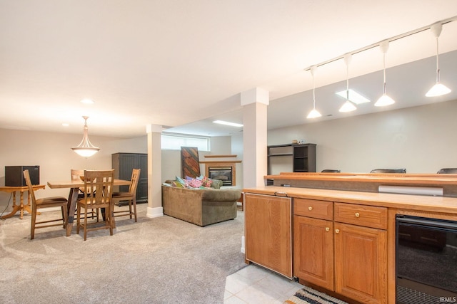 kitchen with pendant lighting, light colored carpet, and beverage cooler