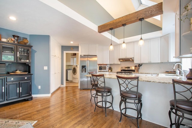 kitchen with white cabinets, stainless steel appliances, sink, and light wood-type flooring