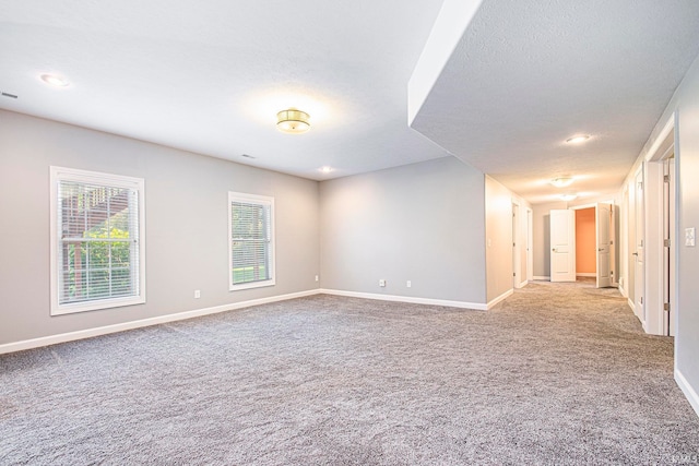 carpeted spare room featuring a textured ceiling