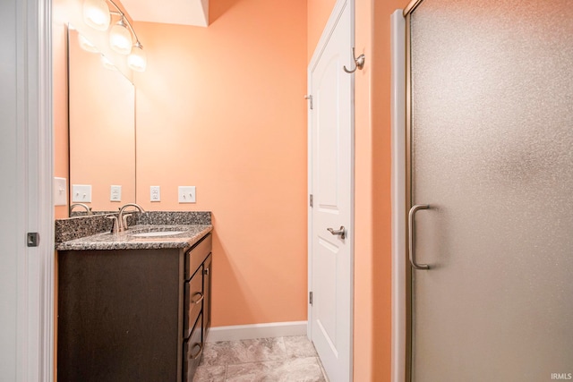 bathroom featuring a shower with door and vanity