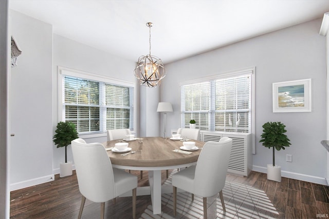 dining area with dark wood-type flooring and an inviting chandelier