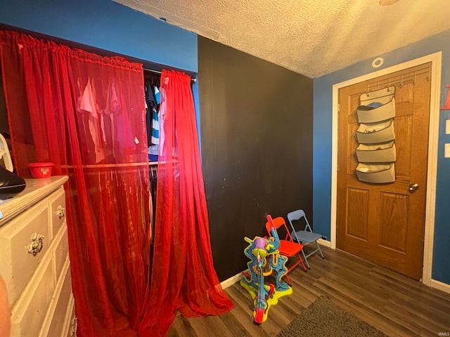 game room with hardwood / wood-style floors and a textured ceiling