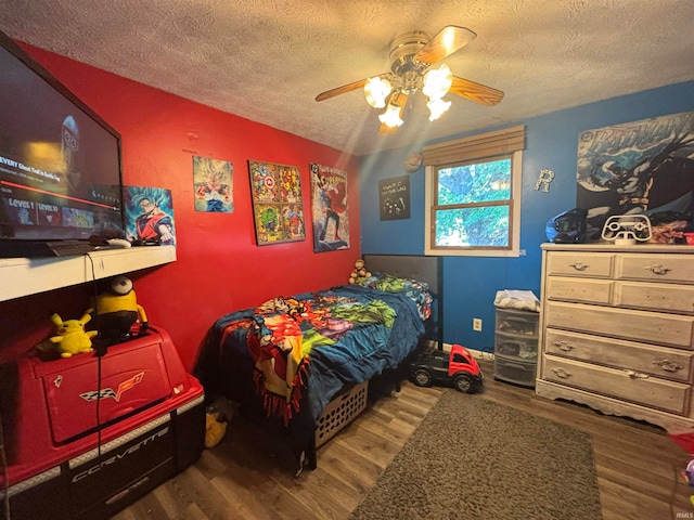 bedroom featuring ceiling fan, hardwood / wood-style flooring, and a textured ceiling