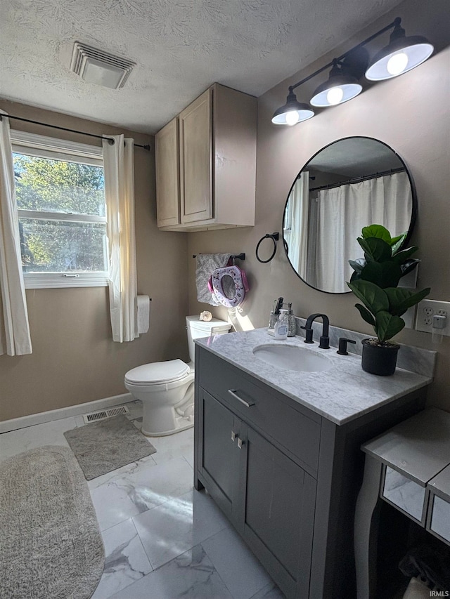 bathroom with toilet, a textured ceiling, and vanity