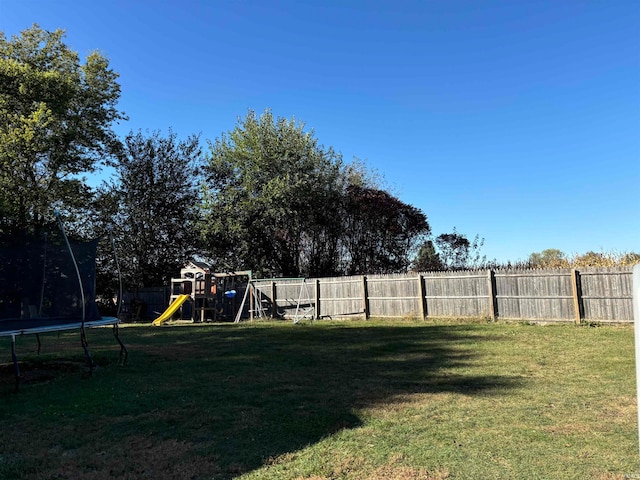 view of yard featuring a playground and a trampoline