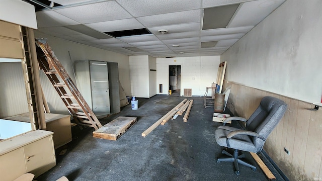 miscellaneous room with wood walls and a drop ceiling