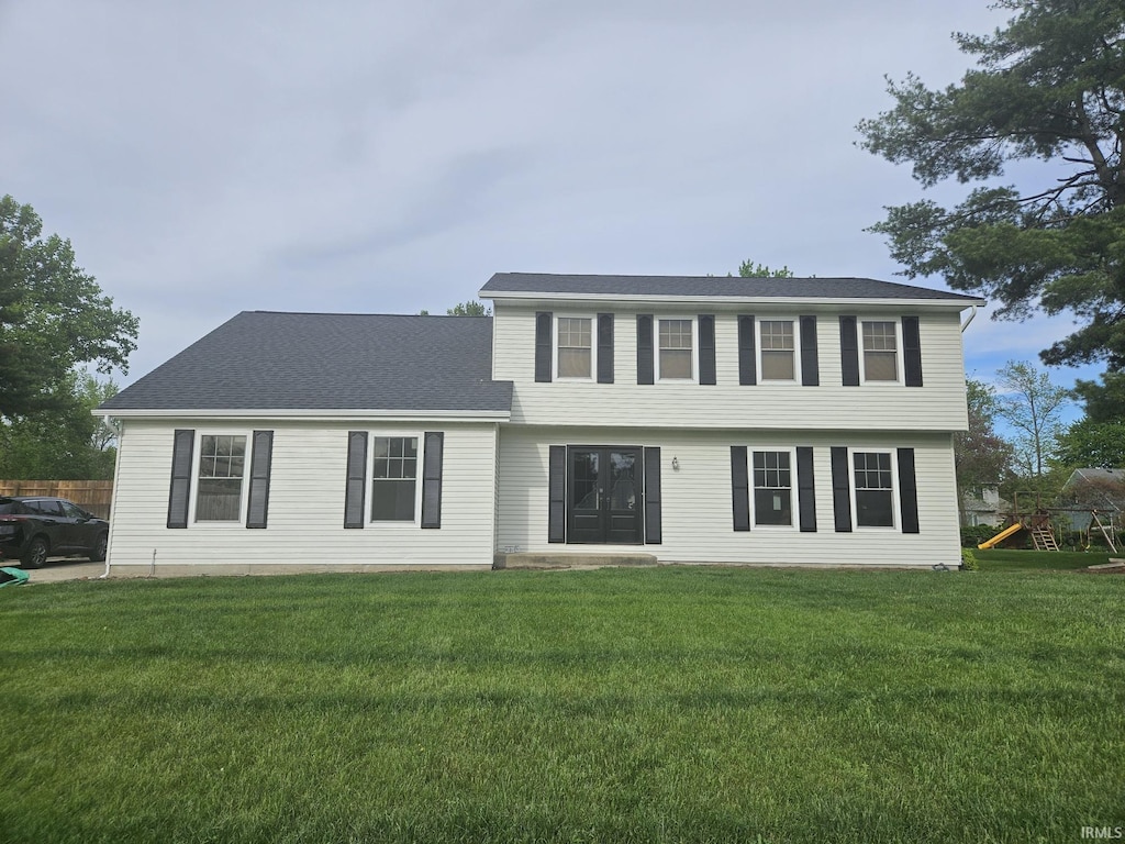 view of front of house with a front lawn and a playground