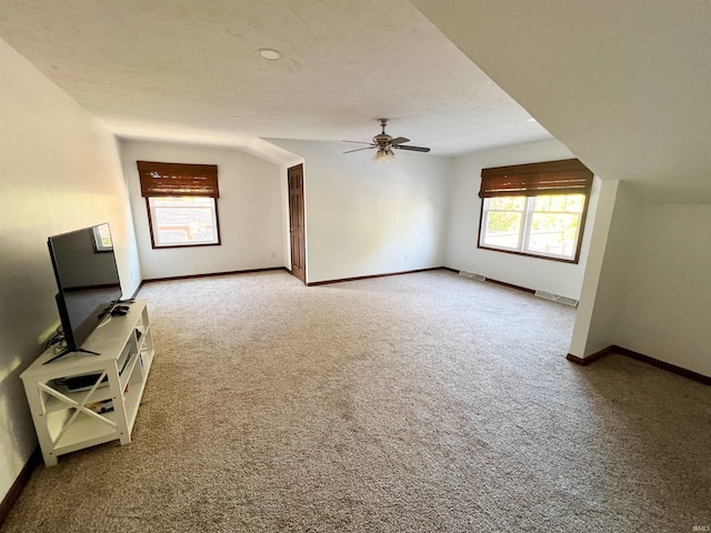 unfurnished living room with ceiling fan, carpet flooring, and lofted ceiling