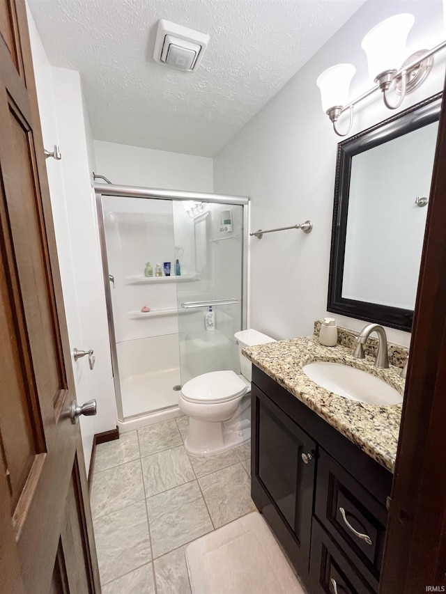 bathroom featuring vanity, a textured ceiling, toilet, and an enclosed shower