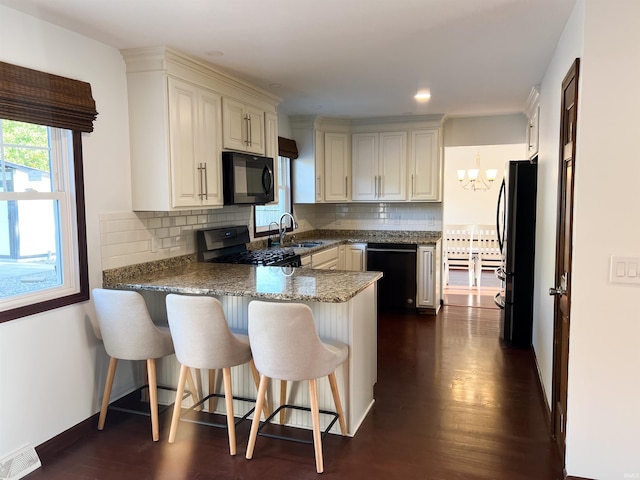 kitchen with backsplash, black appliances, sink, and dark hardwood / wood-style flooring