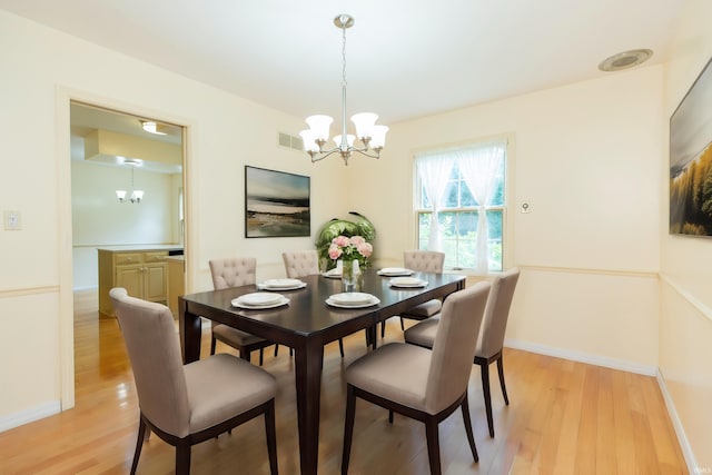 dining room with a chandelier and light wood-type flooring