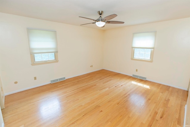 empty room featuring a wealth of natural light, light hardwood / wood-style floors, and ceiling fan