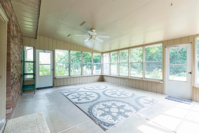 unfurnished sunroom with vaulted ceiling, ceiling fan, and plenty of natural light