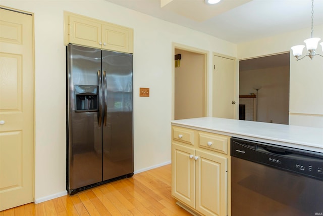 kitchen with appliances with stainless steel finishes, decorative light fixtures, light wood-type flooring, and an inviting chandelier