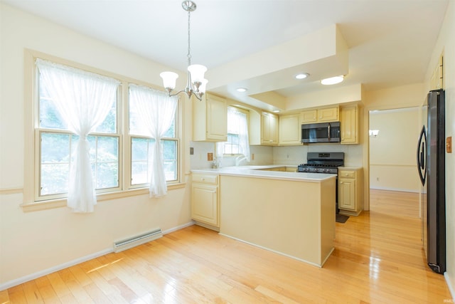 kitchen featuring light hardwood / wood-style flooring, decorative light fixtures, kitchen peninsula, and stainless steel appliances